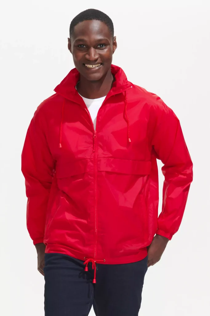 homme souriant qui porte un coupe vent rouge